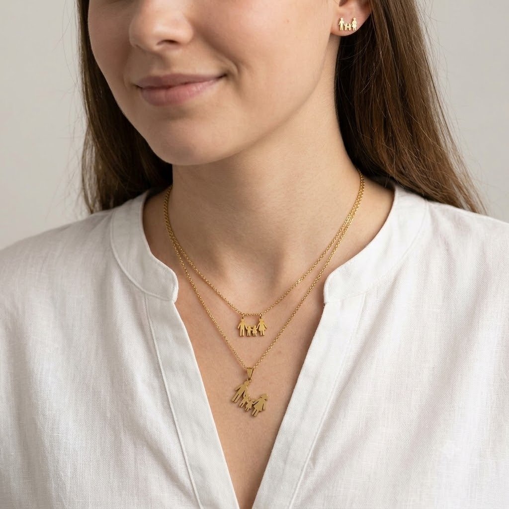 سلسلة الحرف الذهبي الراقية (Initial Necklace) – مطليّة بالذهب ومرصعة بفصوص الزركون اللامعة امرأة ترتدي طقم مجوهرات ذهبي بتصميم العائلة، يتكون من قلادة بسلسلة مزدوجة (طبقتين) تحمل دلايات صغيرة على شكل شخصيات عائلية (أب وأم وطفل يمسكون بأيدي بعضهم)، مع أقراط (حلق) صغيرة متطابقة بنفس التصميم.