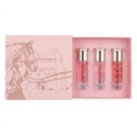 Assaf Arrogate Collection miniature perfume set in a light pink presentation box featuring an illustration of a woman, a horse, and an ancient desert temple, alongside three glass spray bottles with silver caps containing pink shades of liquid.